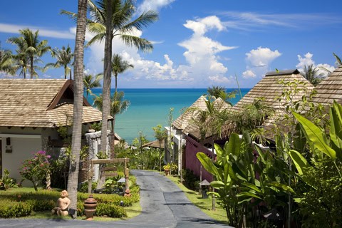 Beachfront resort in Koh Samui, Thailand surrounded by palm trees and turquoise sea