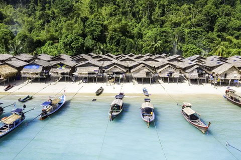 Overwater bungalows and boats along the Similan Islands in southern Thailand